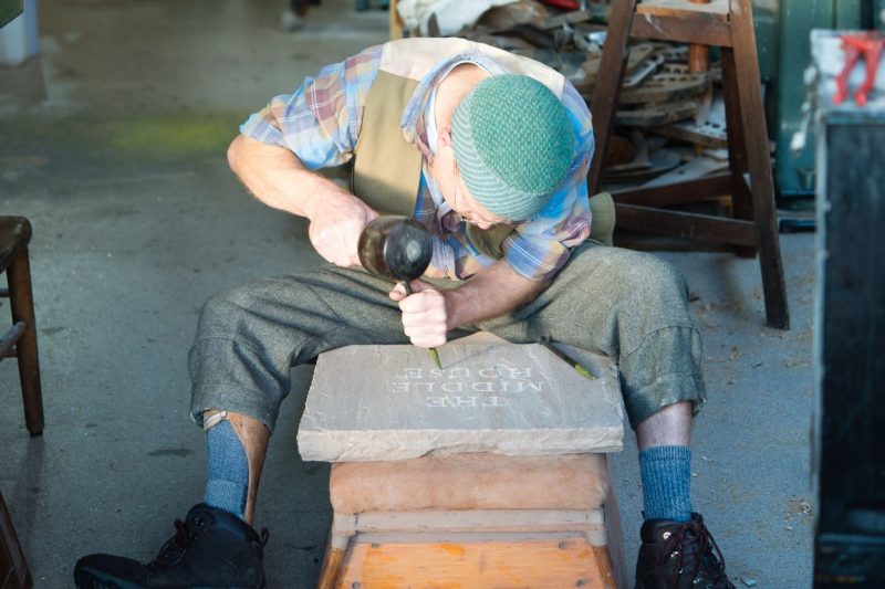 Sculptur Phil Neal working on a stone carving in his studio