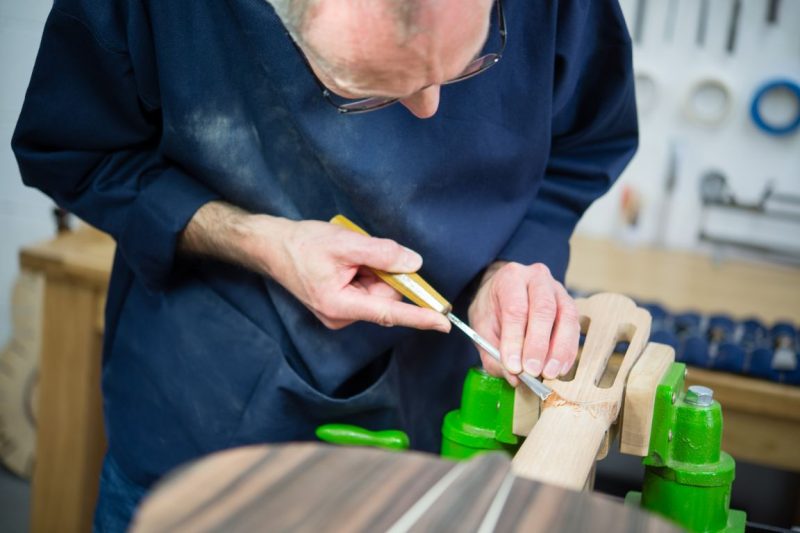 A close up of guitar maker Richard Hartley making a guitar in the studio