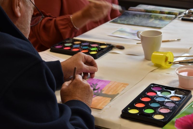 A close up of a Memory Loss session with a participant making a watercolour painting