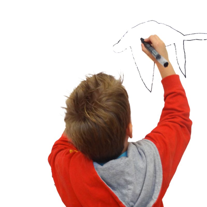 A child in a red jumper making a drawing