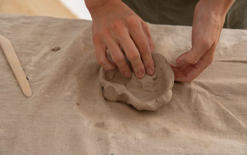 Beginners Pottery Class - Close up of a potters hands working with clay