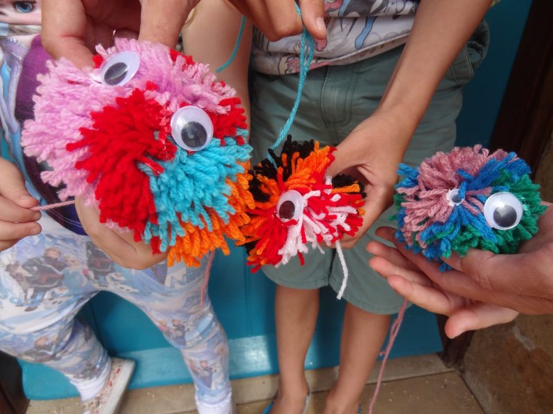 Children holding pom pom crafts