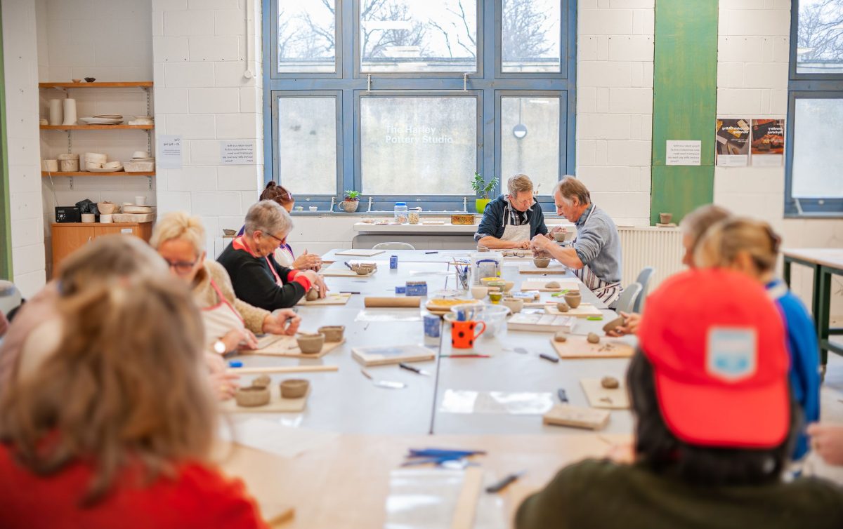 People at a table making pottery